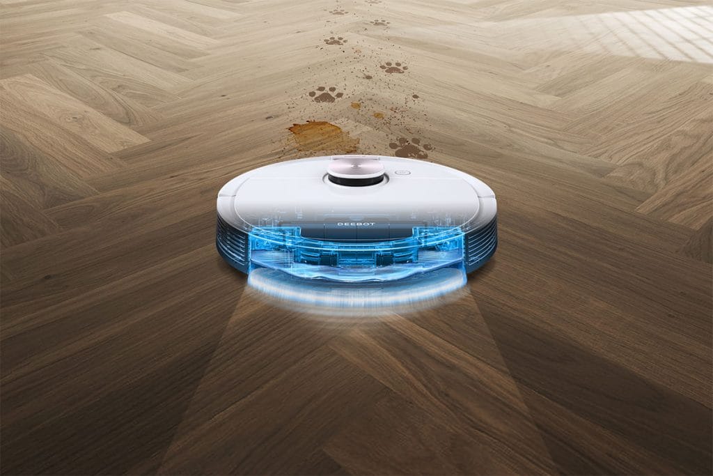 Robot aspirador detectando y limpiando manchas sobre suelo de madera